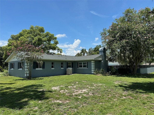 219 Magnolia Cir, Eustis, FL 32726 - back of house featuring a lawn and a chimney