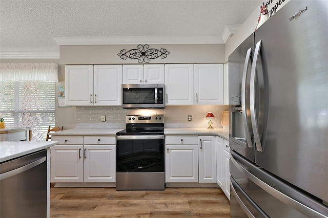 1309 Corona Ave, The Villages, FL 32159 - kitchen with stainless steel appliances, crown molding, a textured ceiling, light countertops, and white cabinetry