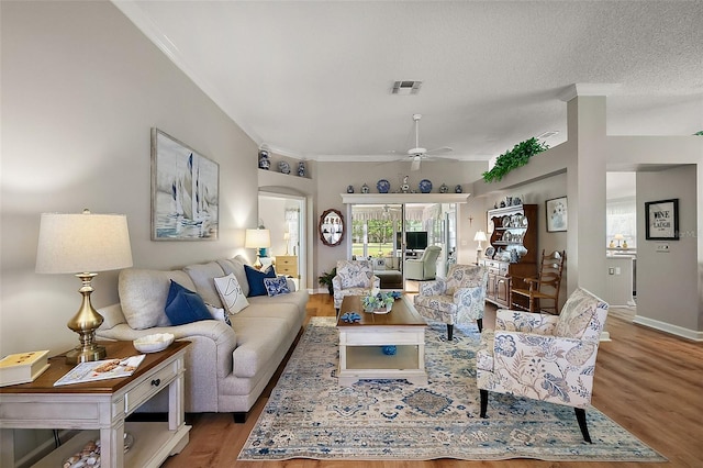 1309 Corona Ave, The Villages, FL 32159 - living room with wood finished floors, crown molding, a ceiling fan, and arched walkways