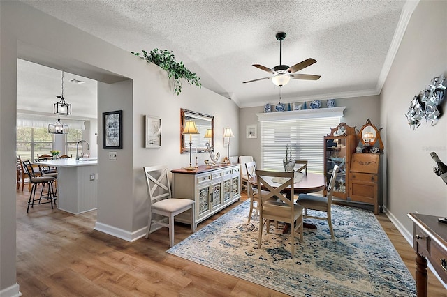 1309 Corona Ave, The Villages, FL 32159 - dining room featuring a textured ceiling, wood finished floors, a ceiling fan, ornamental molding, and vaulted ceiling