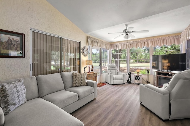 1309 Corona Ave, The Villages, FL 32159 - living area featuring a textured wall, vaulted ceiling, a ceiling fan, and wood finished floors