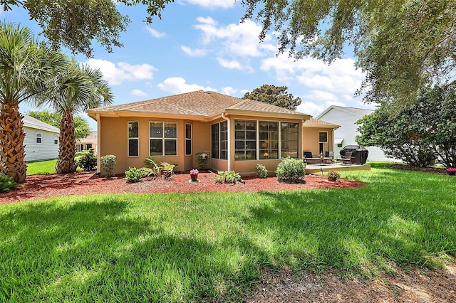 1309 Corona Ave, The Villages, FL 32159 - rear view of house with stucco siding, a sunroom, a yard, and roof with shingles