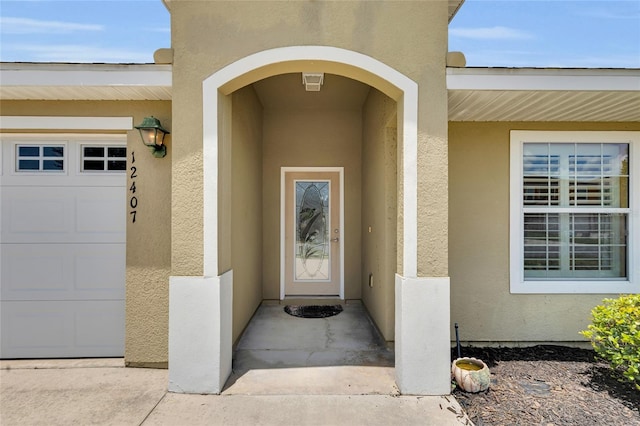 12407 NE 48th Loop, Oxford, FL 34484 - property entrance featuring stucco siding and an attached garage