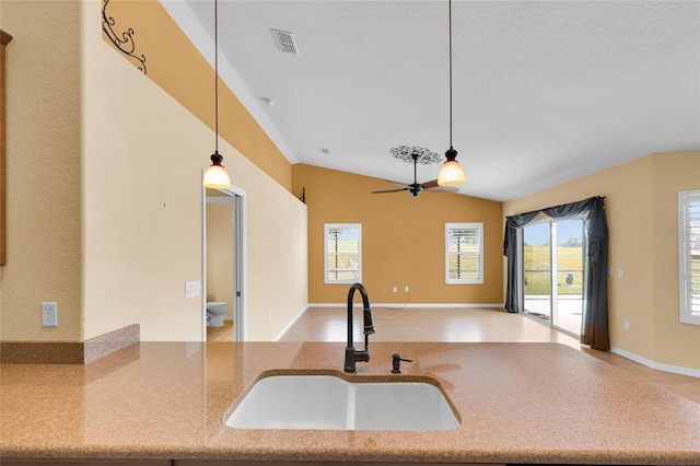 12407 NE 48th Loop, Oxford, FL 34484 - kitchen with open floor plan, pendant lighting, light stone countertops, ceiling fan, and a textured ceiling