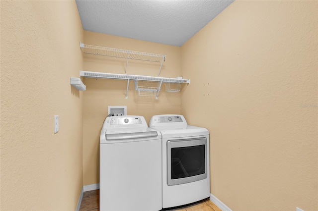 12407 NE 48th Loop, Oxford, FL 34484 - washroom featuring washing machine and dryer, light tile patterned floors, a textured ceiling, and a textured wall
