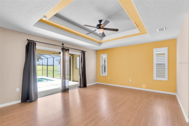 12407 NE 48th Loop, Oxford, FL 34484 - unfurnished room with a textured ceiling, a raised ceiling, a ceiling fan, and wood finished floors
