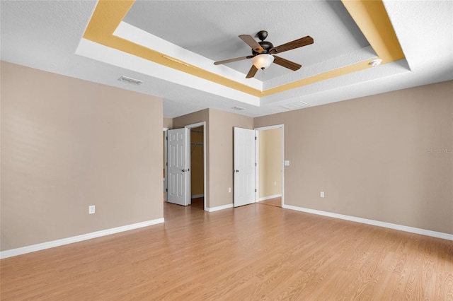 12407 NE 48th Loop, Oxford, FL 34484 - unfurnished room with a tray ceiling, ceiling fan, and light wood finished floors
