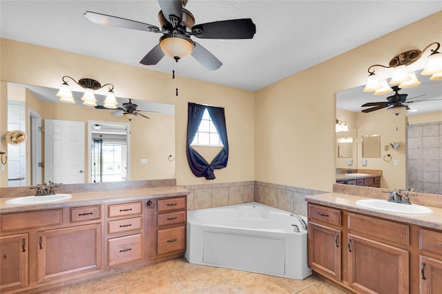 12407 NE 48th Loop, Oxford, FL 34484 - bathroom with a ceiling fan, two vanities, a bath, and tile patterned flooring
