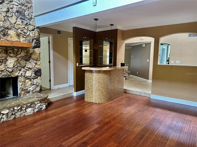 1096 Linkside Ct, Apopka, FL 32712 - unfurnished living room featuring light wood finished floors, arched walkways, a fireplace, and ornamental molding