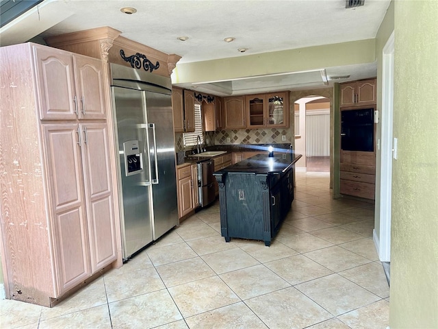 1096 Linkside Ct, Apopka, FL 32712 - kitchen with built in fridge, oven, arched walkways, dark countertops, and decorative backsplash