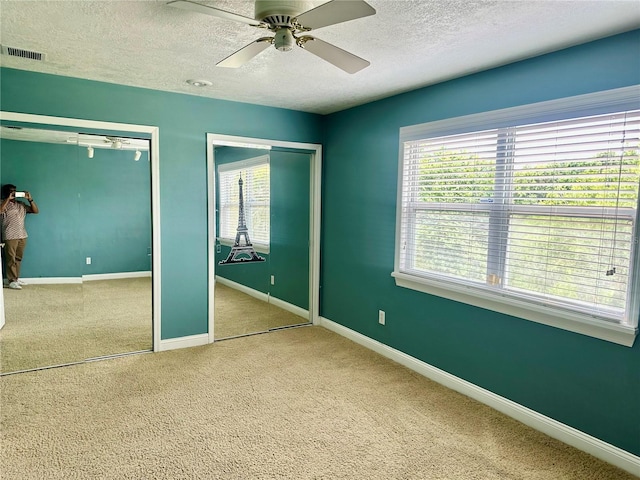 1096 Linkside Ct, Apopka, FL 32712 - unfurnished bedroom with two closets, a textured ceiling, carpet flooring, and ceiling fan