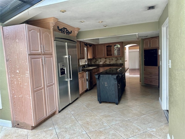 1096 Linkside Ct, Apopka, FL 32712 - kitchen with stainless steel built in fridge, arched walkways, dark countertops, tasteful backsplash, and light tile patterned floors