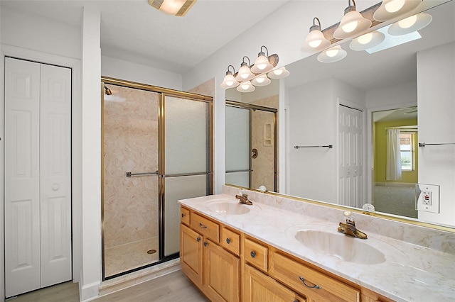 1512 Cervantes Pl, The Villages, FL 32159 - full bathroom featuring a closet, a stall shower, double vanity, and wood finished floors