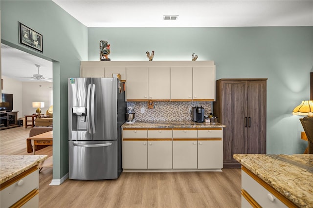 17970 SE 102nd Ct, Summerfield, FL 34491 - kitchen with stainless steel fridge with ice dispenser, light wood finished floors, and decorative backsplash