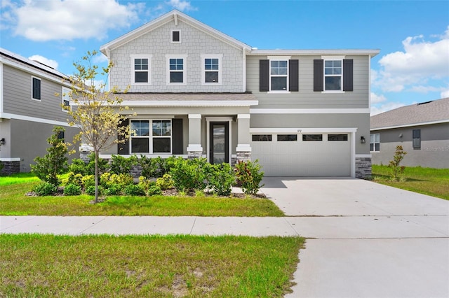 872 Griffon Ave, Lake Alfred, FL 33850 - craftsman-style house featuring driveway, an attached garage, stone siding, and a front yard
