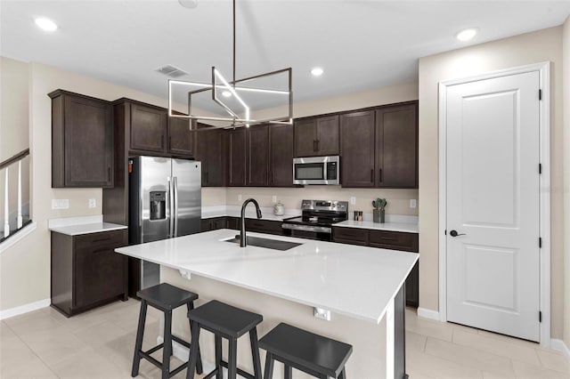 872 Griffon Ave, Lake Alfred, FL 33850 - kitchen with stainless steel appliances, dark brown cabinetry, light countertops, a breakfast bar, and recessed lighting