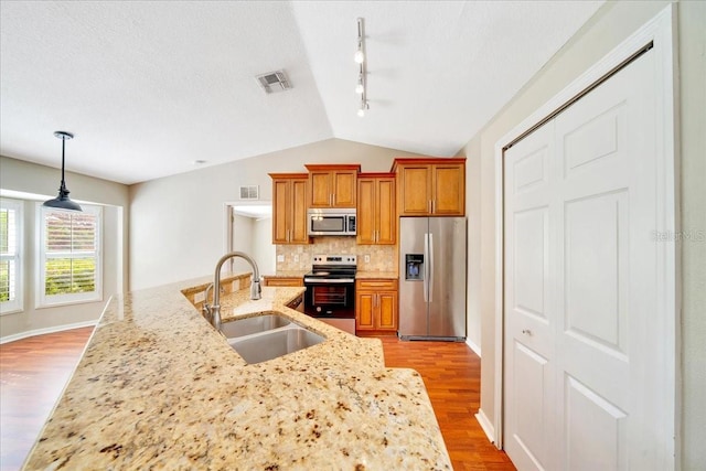 10331 SW 45th Ave, Ocala, FL 34476 - kitchen featuring stainless steel appliances, track lighting, vaulted ceiling, light wood-style flooring, and tasteful backsplash