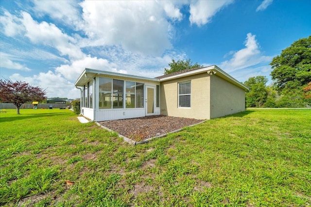10331 SW 45th Ave, Ocala, FL 34476 - rear view of house featuring a sunroom, a lawn, and stucco siding