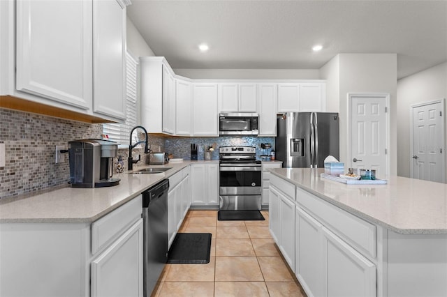3467 Buoy Cir, Winter Garden, FL 34787 - kitchen with stainless steel appliances, a kitchen island, backsplash, white cabinetry, and light tile patterned floors