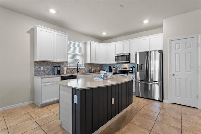 3467 Buoy Cir, Winter Garden, FL 34787 - kitchen with stainless steel appliances, tasteful backsplash, white cabinets, light tile patterned flooring, and a kitchen island