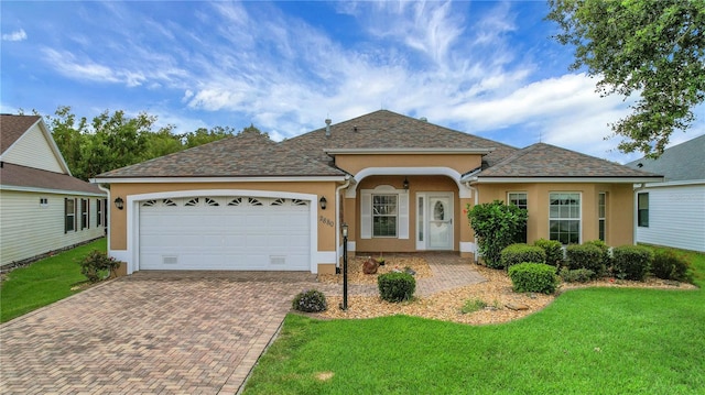2880 Manor Downs, The Villages, FL 32162 - view of front of home featuring decorative driveway, stucco siding, a front lawn, and an attached garage