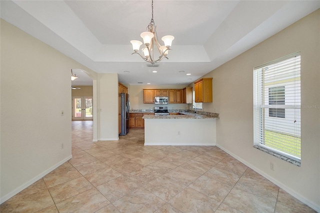 2880 Manor Downs, The Villages, FL 32162 - kitchen featuring stainless steel appliances, a chandelier, a raised ceiling, brown cabinetry, and recessed lighting
