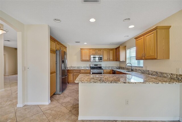 2880 Manor Downs, The Villages, FL 32162 - kitchen featuring stainless steel appliances, a peninsula, light stone countertops, arched walkways, and recessed lighting