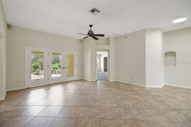 2880 Manor Downs, The Villages, FL 32162 - spare room featuring arched walkways, a ceiling fan, french doors, and light tile patterned floors
