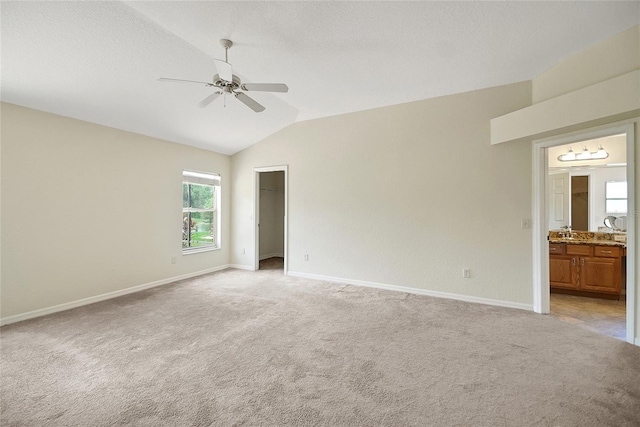 2880 Manor Downs, The Villages, FL 32162 - unfurnished bedroom featuring lofted ceiling, light colored carpet, a ceiling fan, ensuite bathroom, and a walk in closet
