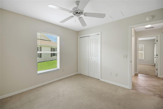 2880 Manor Downs, The Villages, FL 32162 - unfurnished bedroom featuring carpet flooring, a closet, a ceiling fan, and tile patterned flooring