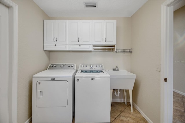 2880 Manor Downs, The Villages, FL 32162 - washroom featuring cabinet space, washer and clothes dryer, and light tile patterned flooring