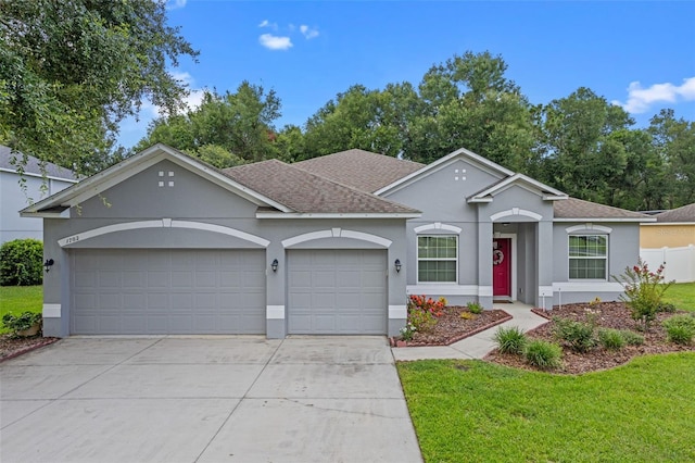 1702 Hoofprint Ct, Fruitland Park, FL 34731 - view of front of house featuring stucco siding, concrete driveway, a shingled roof, a garage, and a front yard