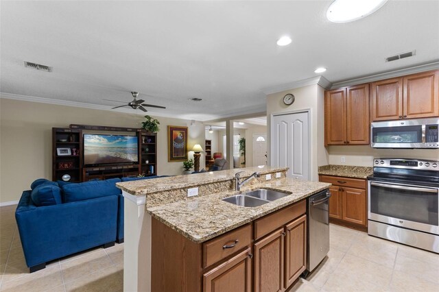 1702 Hoofprint Ct, Fruitland Park, FL 34731 - kitchen featuring stainless steel appliances, open floor plan, light tile patterned floors, crown molding, and brown cabinetry