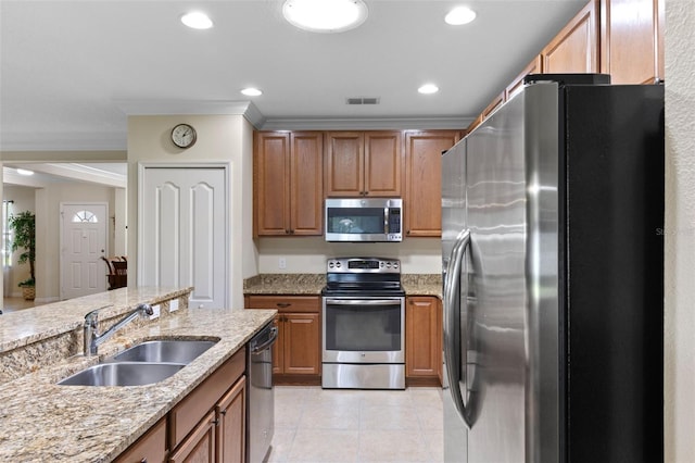 1702 Hoofprint Ct, Fruitland Park, FL 34731 - kitchen with stainless steel appliances, light stone countertops, light tile patterned floors, brown cabinetry, and recessed lighting