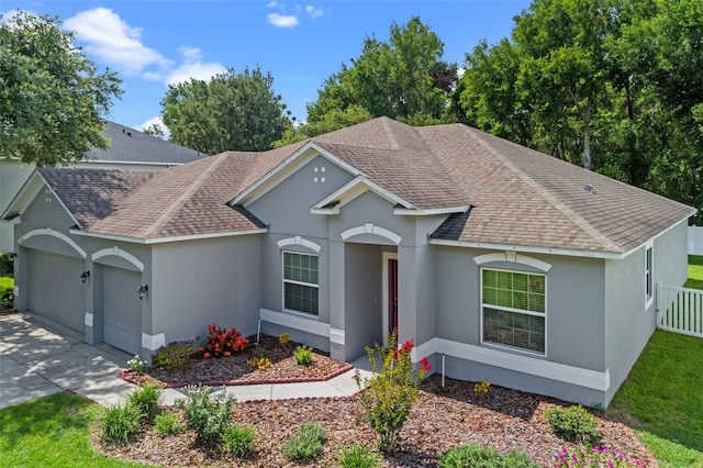 1702 Hoofprint Ct, Fruitland Park, FL 34731 - single story home with roof with shingles, stucco siding, an attached garage, and driveway