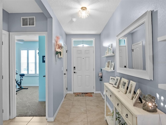 2710 Lilyturf Ct, Tavares, FL 32778 - entrance foyer with light tile patterned floors and a textured ceiling