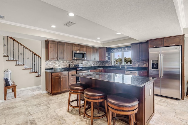 628 Drew Ave, Clermont, FL 34711 - kitchen with appliances with stainless steel finishes, ornamental molding, backsplash, open shelves, and a kitchen bar