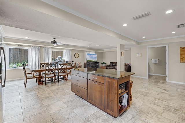 628 Drew Ave, Clermont, FL 34711 - kitchen featuring dark countertops, healthy amount of natural light, a kitchen island, crown molding, and open shelves