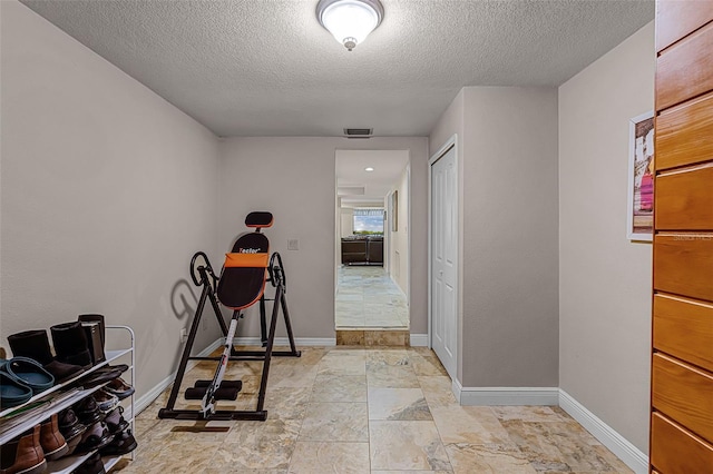 628 Drew Ave, Clermont, FL 34711 - exercise area with a textured ceiling and light stone finish flooring
