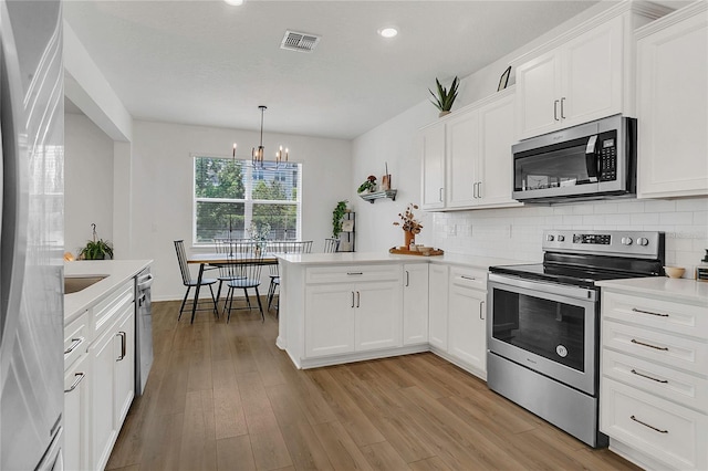 2755 Bobcat Chase Blvd, Oakland, FL 34787 - kitchen with stainless steel appliances, a peninsula, light countertops, a chandelier, and backsplash