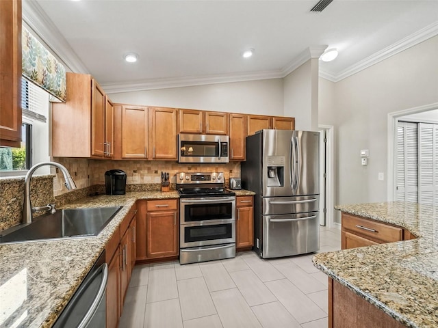 2620 Persimmon Loop, The Villages, FL 32162 - kitchen featuring stainless steel appliances, backsplash, crown molding, brown cabinets, and light stone counters