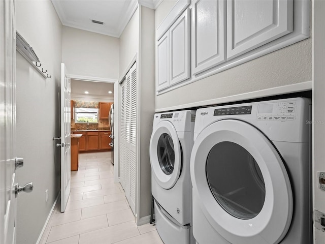 2620 Persimmon Loop, The Villages, FL 32162 - washroom with washing machine and clothes dryer, cabinet space, ornamental molding, and light tile patterned floors