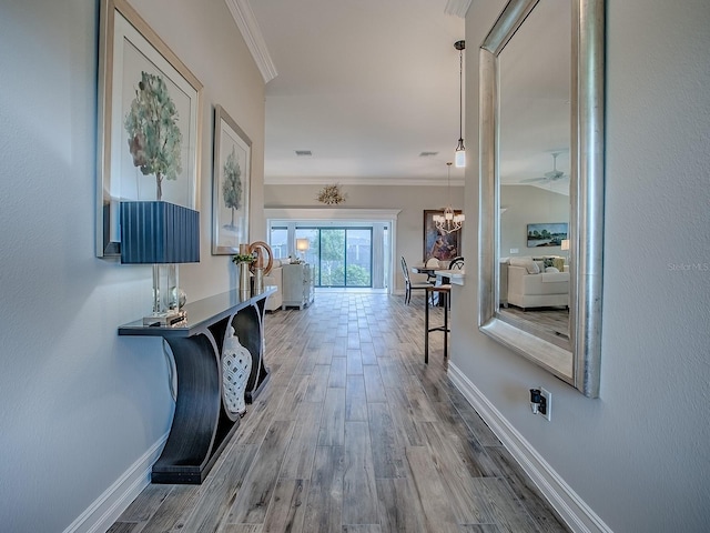 6295 Danielson Loop, The Villages, FL 32163 - corridor with ornamental molding, wood finished floors, and a chandelier