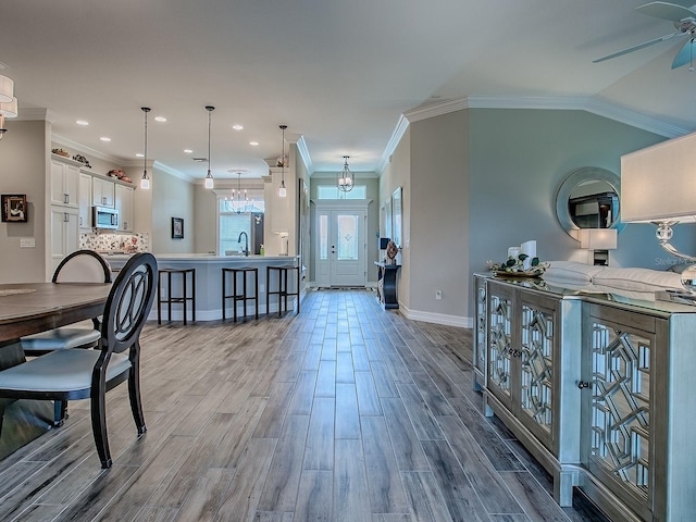 6295 Danielson Loop, The Villages, FL 32163 - kitchen featuring stainless steel microwave, wood finished floors, ceiling fan, white cabinets, and a kitchen breakfast bar