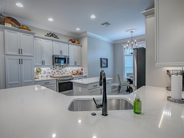 6295 Danielson Loop, The Villages, FL 32163 - kitchen featuring appliances with stainless steel finishes, a chandelier, decorative backsplash, ornamental molding, and recessed lighting