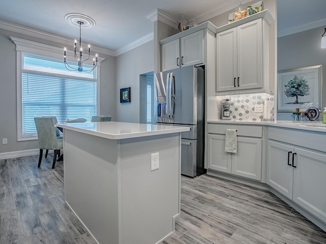 6295 Danielson Loop, The Villages, FL 32163 - kitchen with stainless steel refrigerator with ice dispenser, a chandelier, a center island, light wood-style flooring, and crown molding