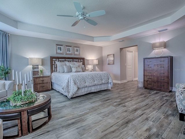 6295 Danielson Loop, The Villages, FL 32163 - bedroom with a raised ceiling and wood finished floors