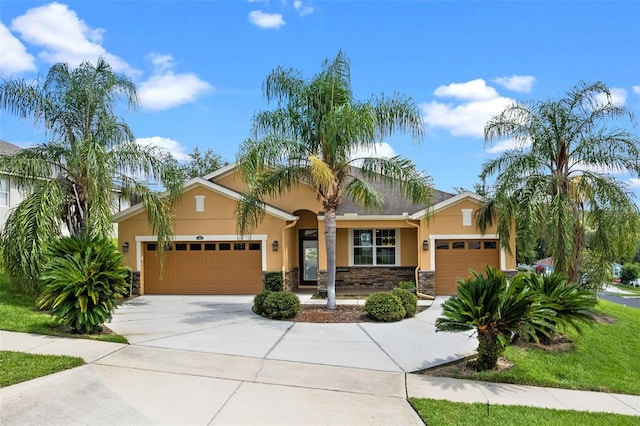 1892 Sanderling Dr, Clermont, FL 34711 - view of front of property with a garage, stucco siding, stone siding, and driveway