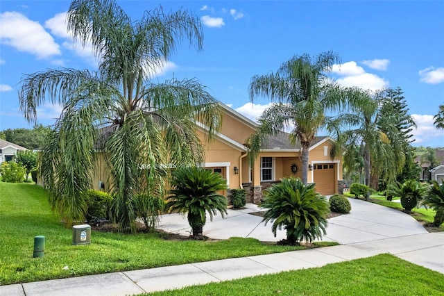 1892 Sanderling Dr, Clermont, FL 34711 - obstructed view of property featuring stucco siding, an attached garage, concrete driveway, a front yard, and stone siding