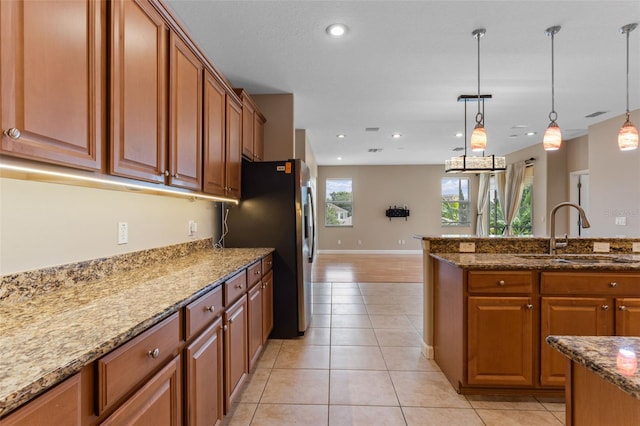 1892 Sanderling Dr, Clermont, FL 34711 - kitchen featuring brown cabinetry, stone countertops, pendant lighting, light tile patterned floors, and recessed lighting